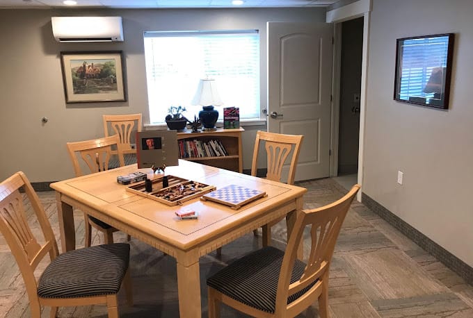 A cozy game room with a wooden table and chairs, featuring board games.