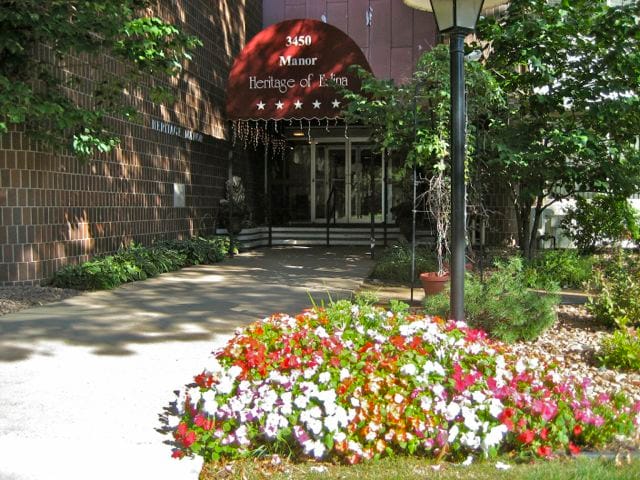 Front entrance of Heritage of Edina with colorful flower beds