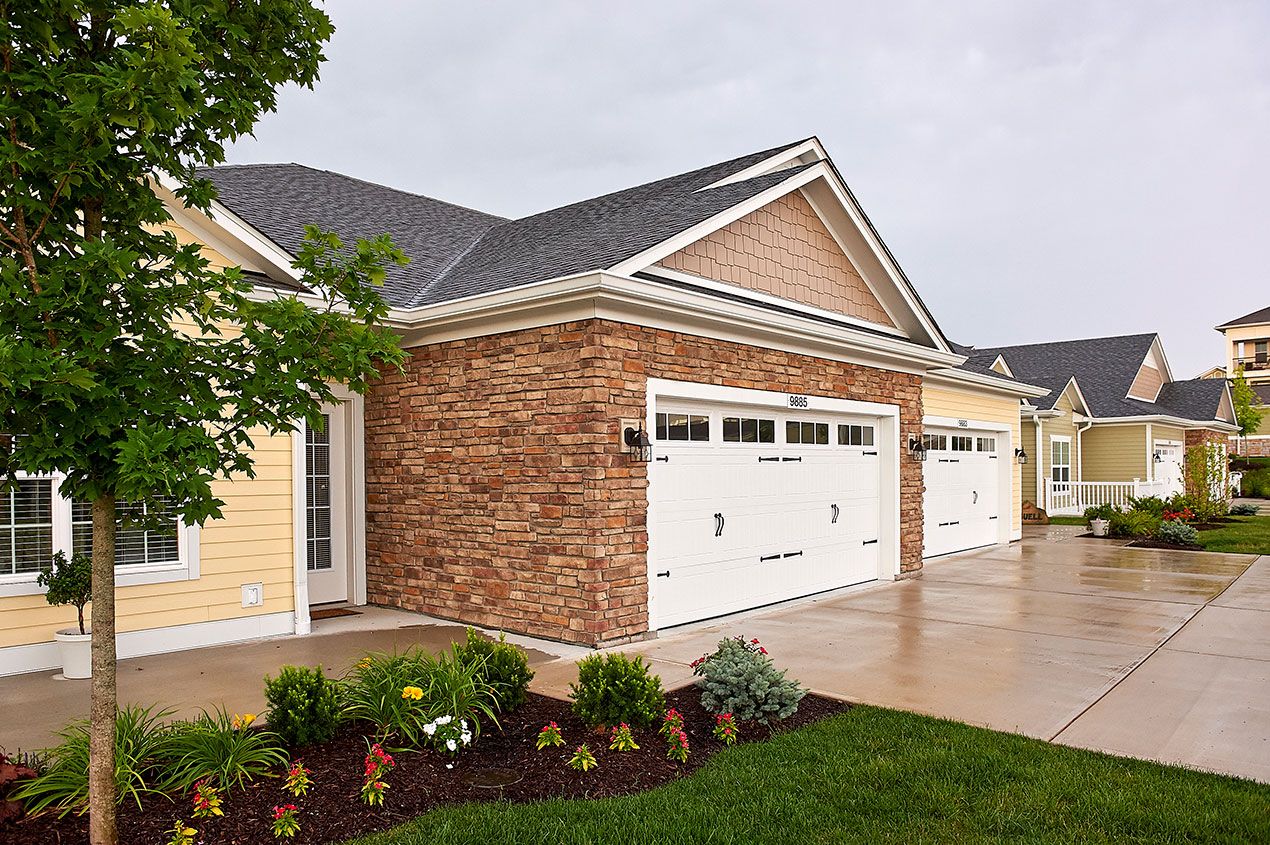 Exterior view of a senior living facility with garages