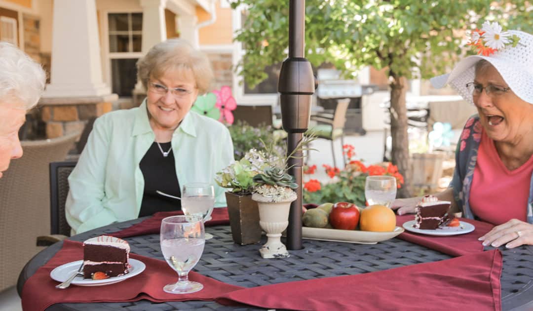 Residents enjoying cake and conversation outdoors