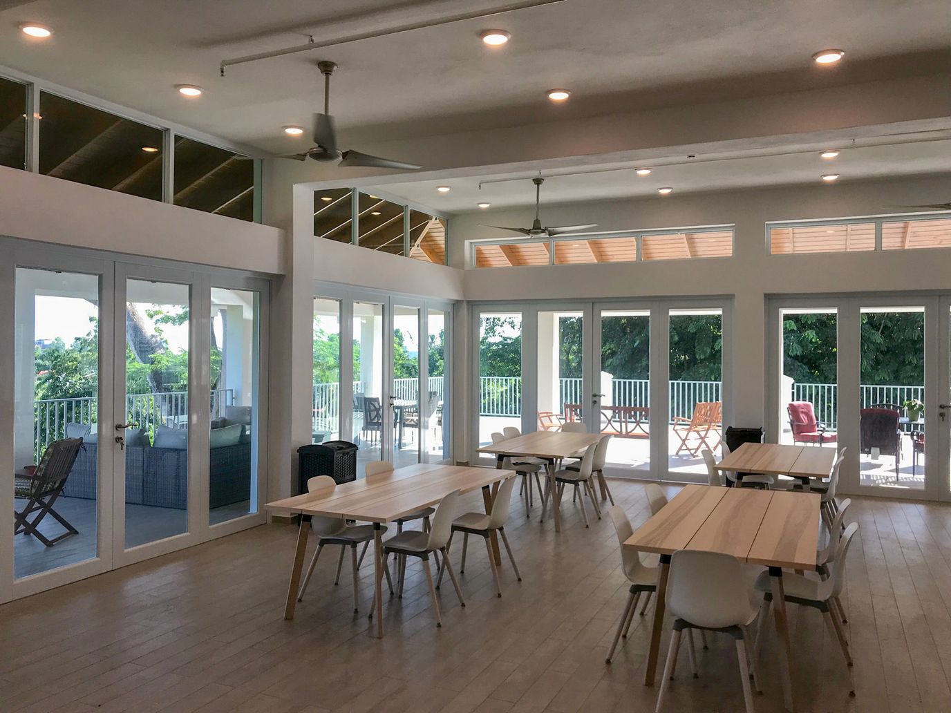 Bright, airy common area with large windows and tables