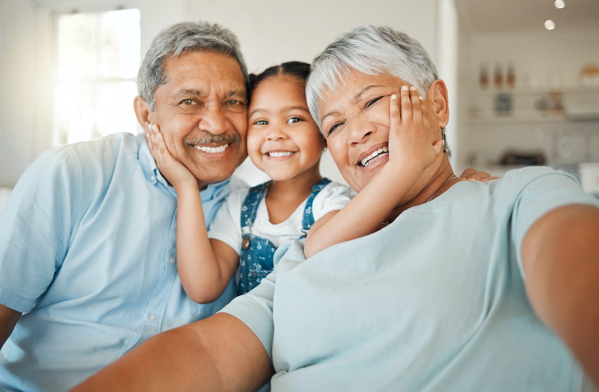 A smiling senior couple with a granddaughter