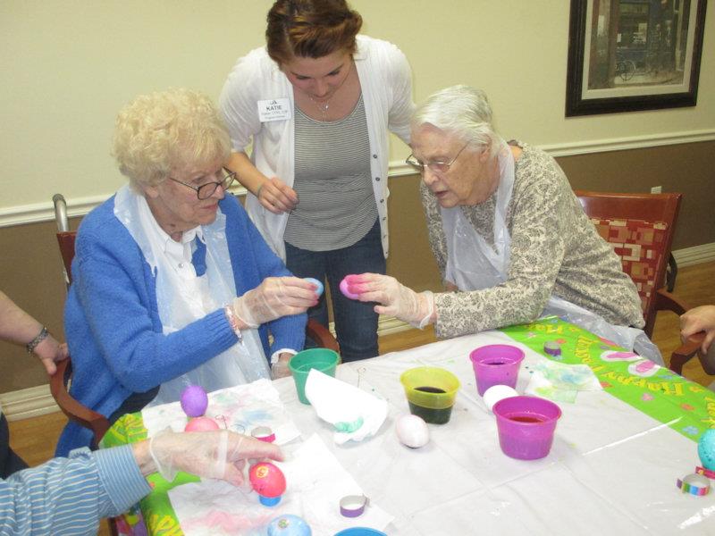 Residents decorating Easter eggs in an activity room