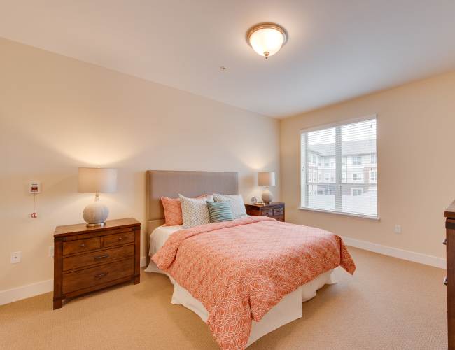 Bright private resident room with a bed and decor