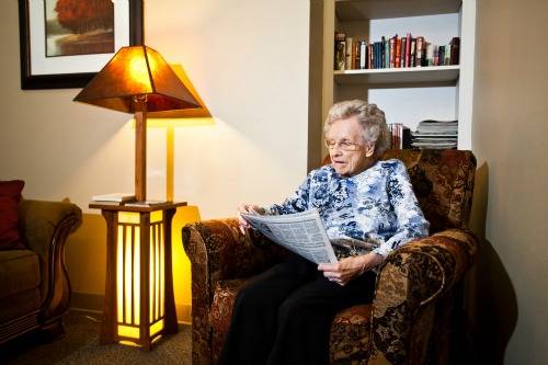 Resident reading in a cozy living room chair