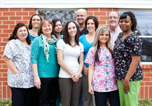 Group of staff members posing outside the facility
