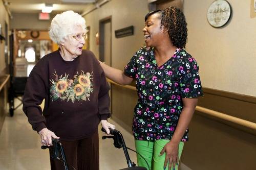 Staff member assisting a resident in a corridor