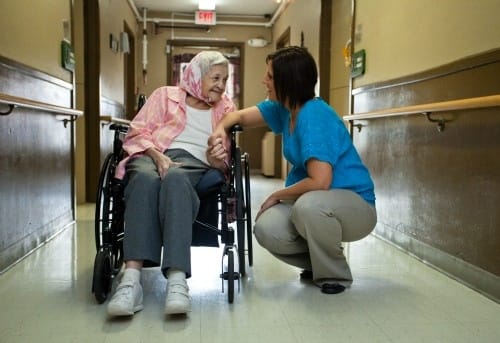 Caregiver interacting with a resident in a hallway