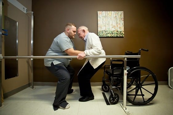Therapist assisting a senior in a rehabilitation session