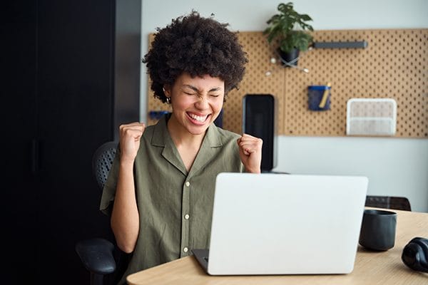 Smiling person celebrating at a desk
