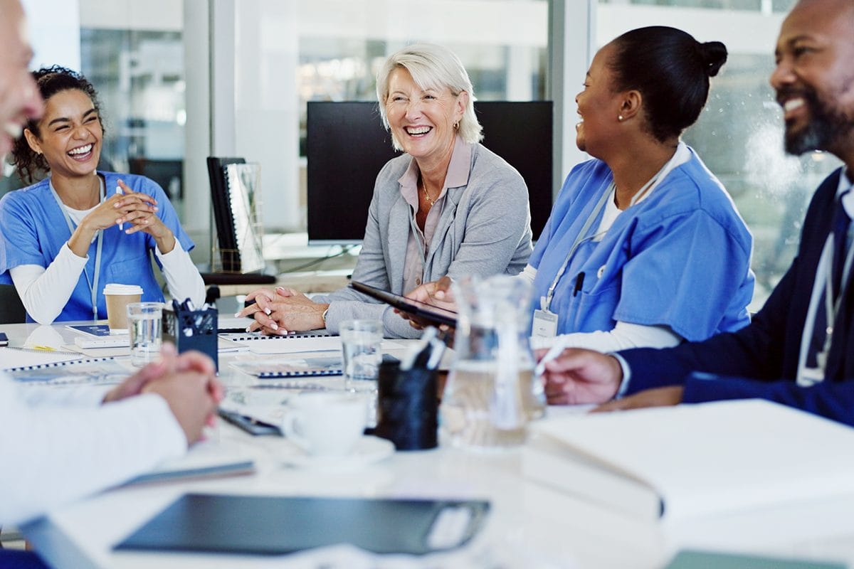 Group of caregivers laughing in a meeting