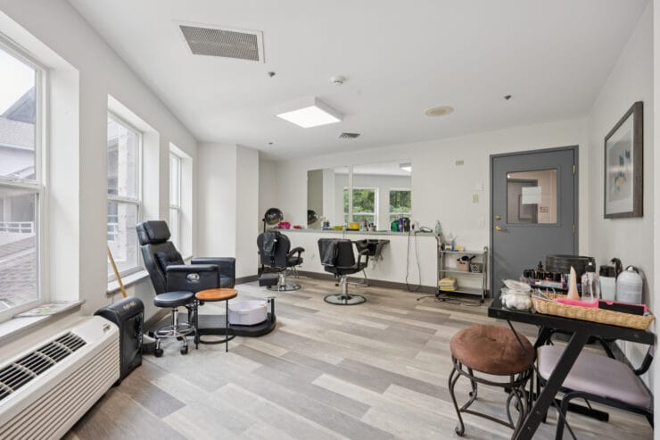 Interior view of a beauty salon area with chairs and mirrors.