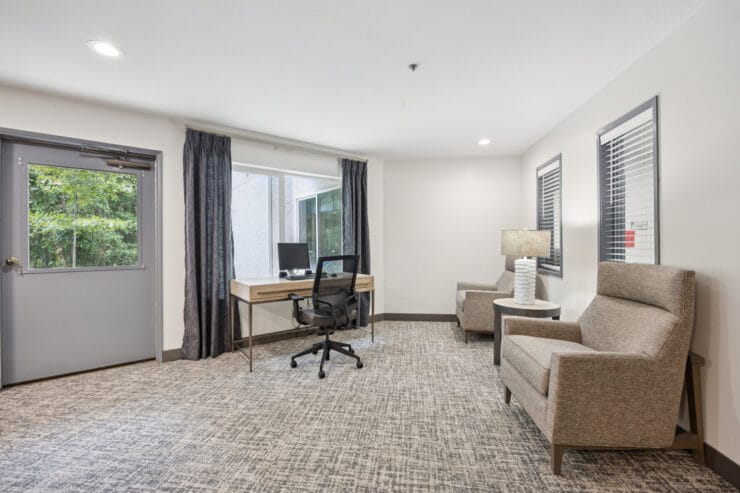 Bright interior lounge with seating and a desk.