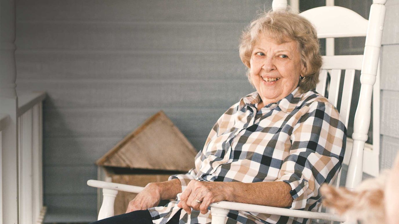 Smiling resident sitting on a rocking chair