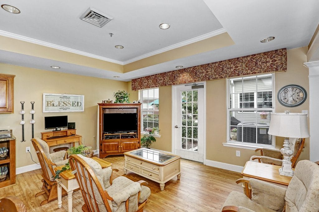 Cozy lounge area with chairs, a television, and natural light.