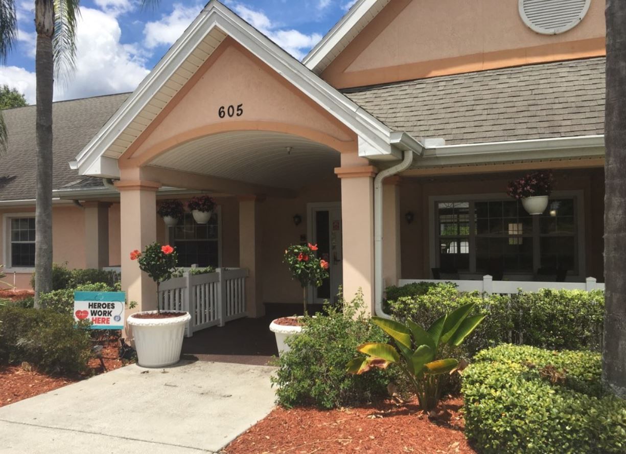 Entrance to Savannah Cottage featuring flower pots and a welcoming sign.
