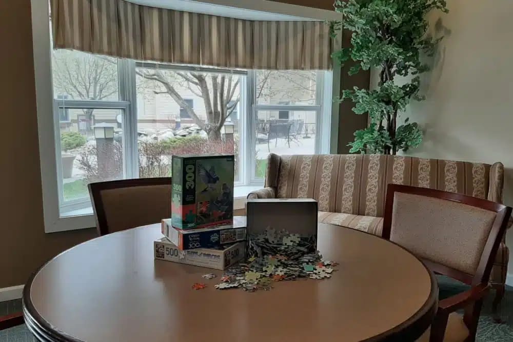 Table with puzzle boxes and pieces in a common area.