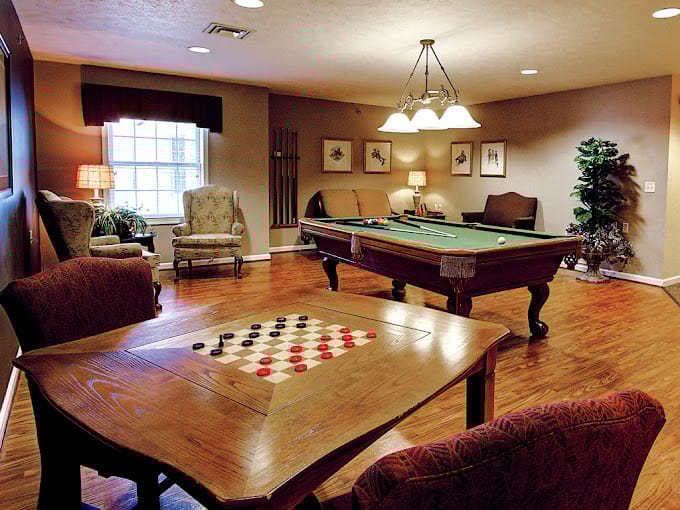 Game room with a pool table and checkers board at The Heritage at Shalimar Gardens.