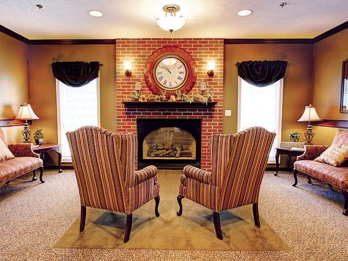 Striped armchairs facing a fireplace in a warm living room.