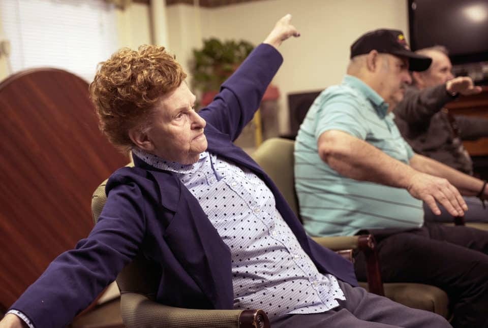 Residents participating in a seated stretching activity