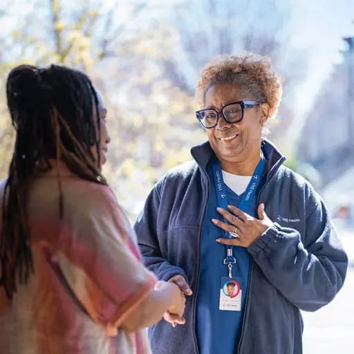 Staff interacting with a resident in a garden area