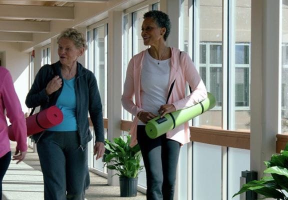 Residents engaging in a wellness activity in a bright hallway