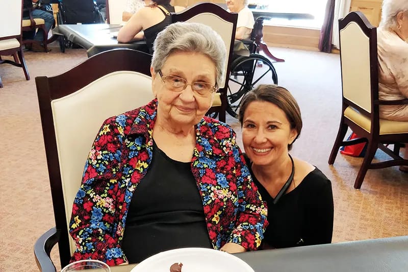 A resident and staff member sharing a moment in a common area