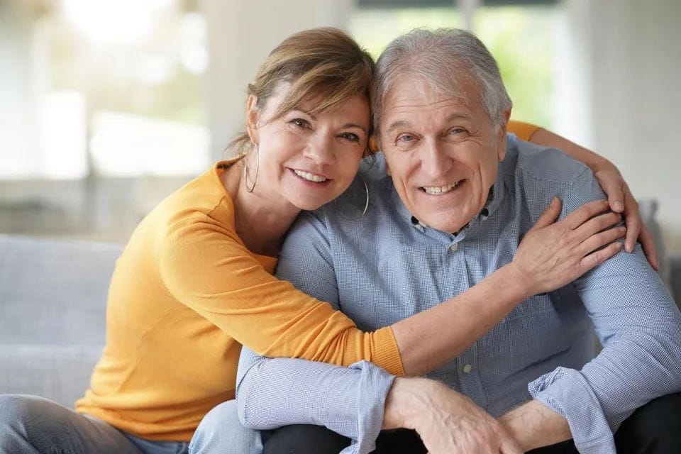 Happy seniors sharing a joyful moment indoors.