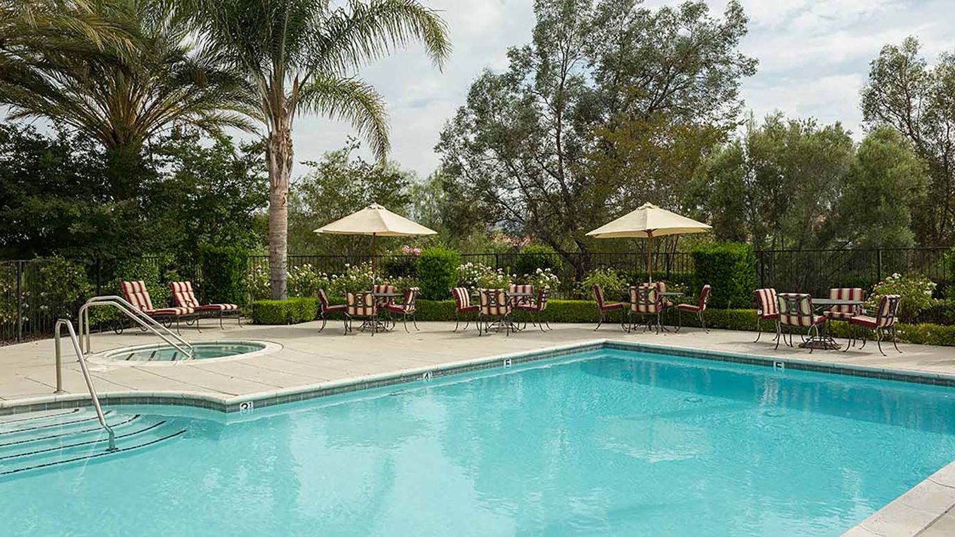 Serene pool area with seating at Atria Park of Vintage Hills