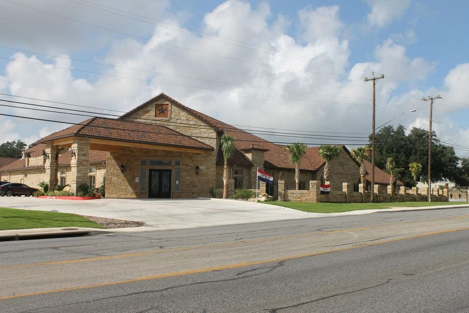 Exterior view of Heritage Creek senior living facility showing entrance and landscaping.
