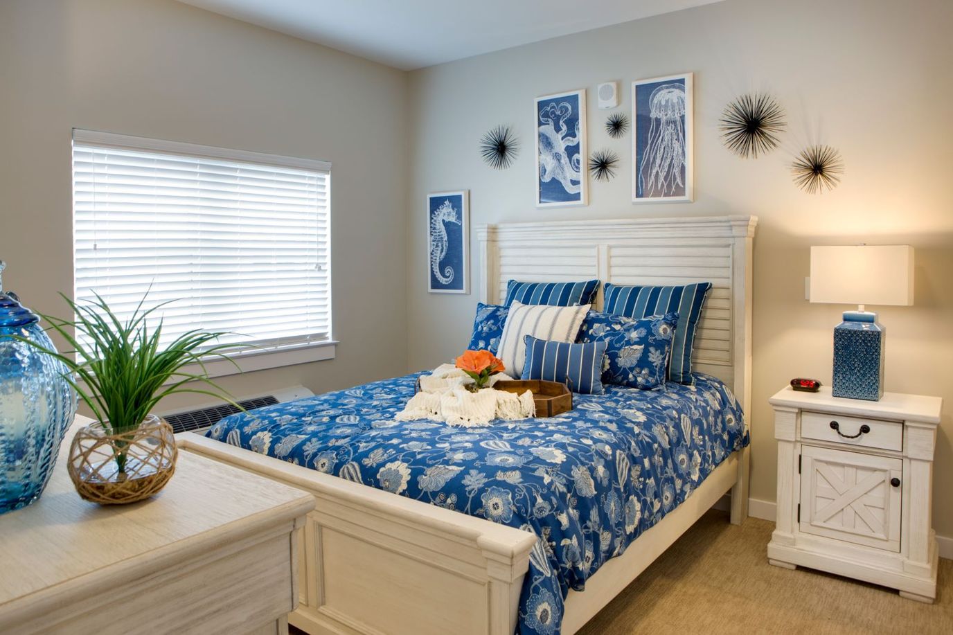 Brightly decorated bedroom with blue floral bedding and decorative wall art