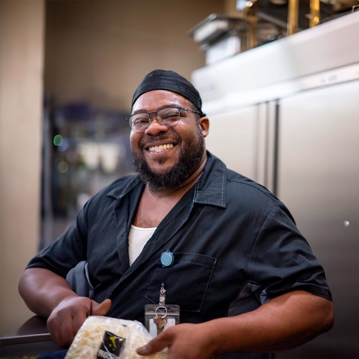 A staff member smiling while holding a food package
