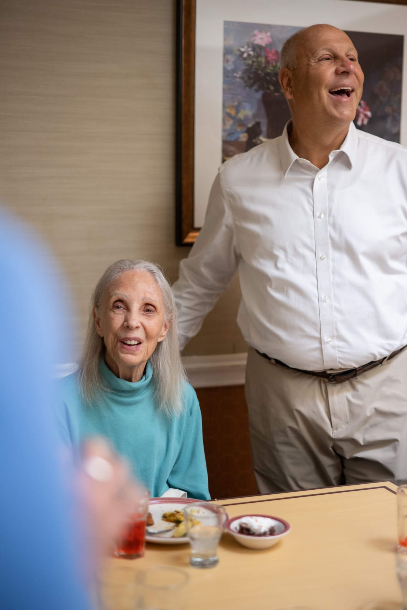 Residents enjoying a meal and conversation in a dining area.