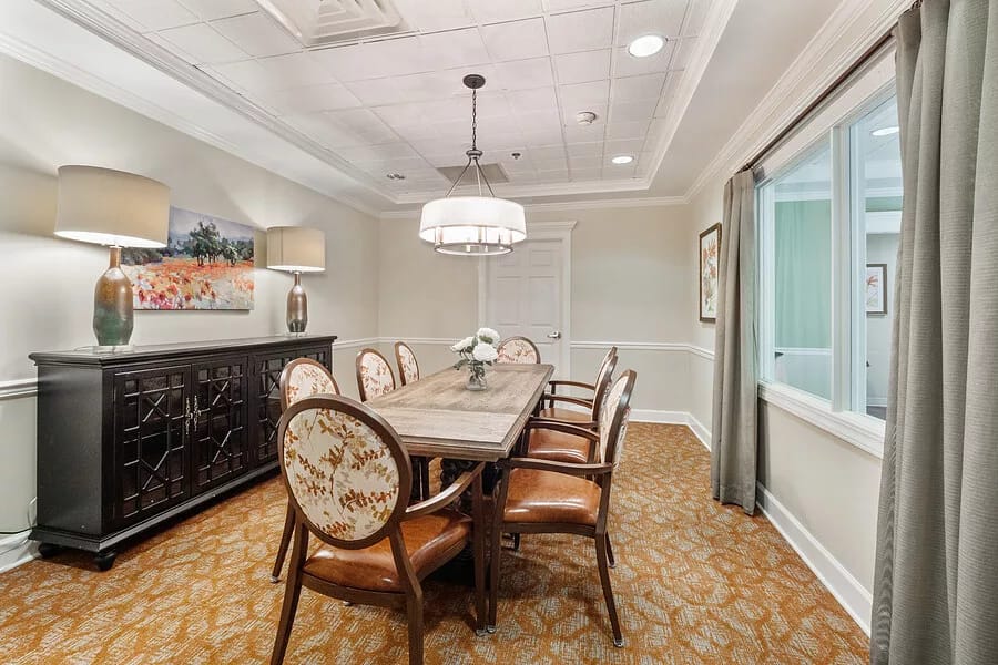 Dining table with wooden chairs and decor in a well-lit room