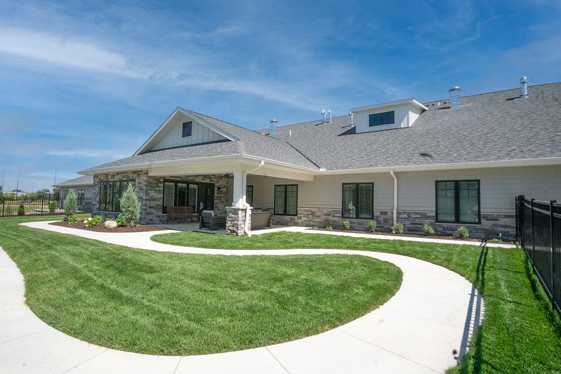 Exterior view of Northwoods Memory Care Suites with landscaped pathway