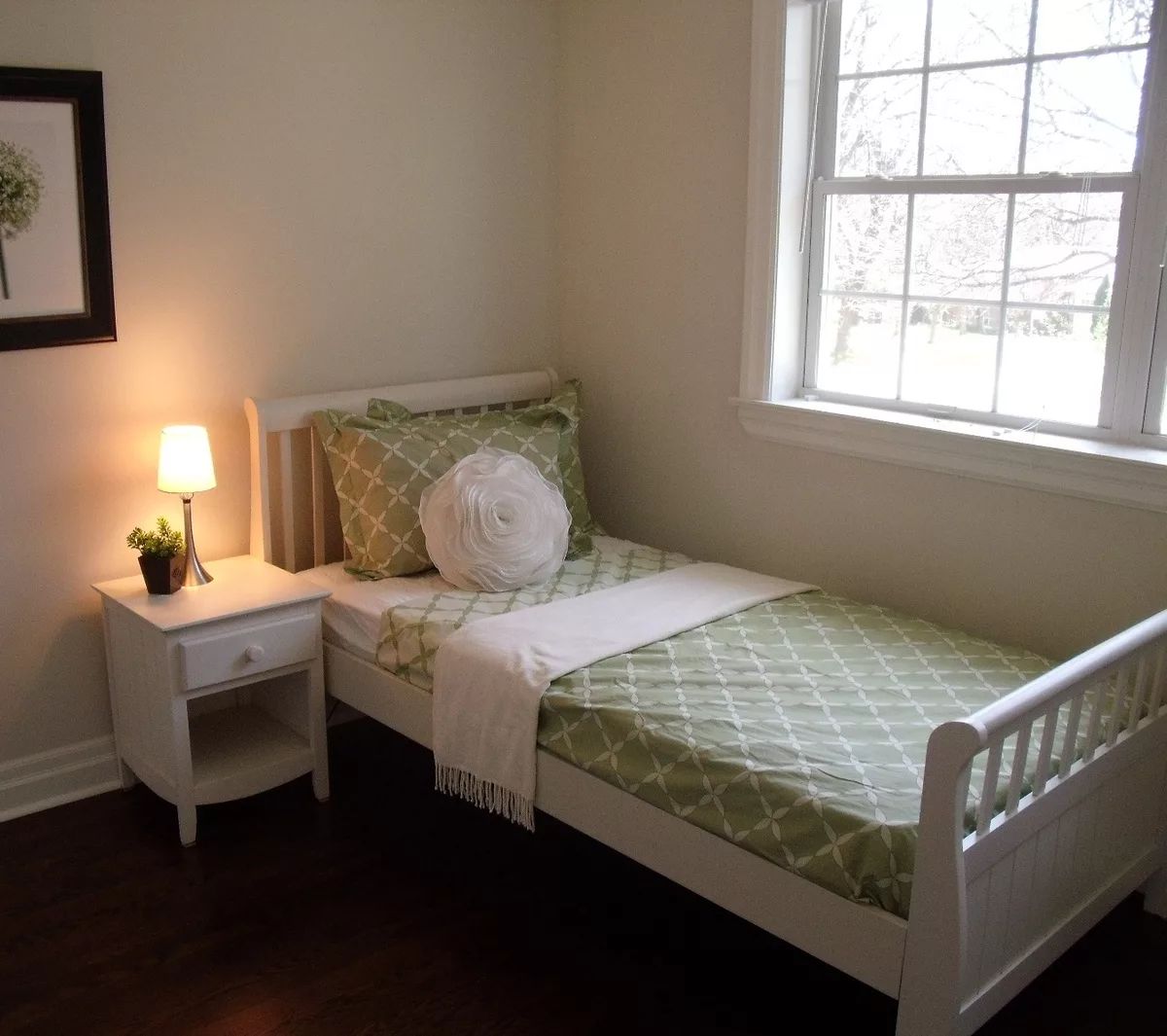 Well-decorated bedroom with a single bed, nightstand, and window.