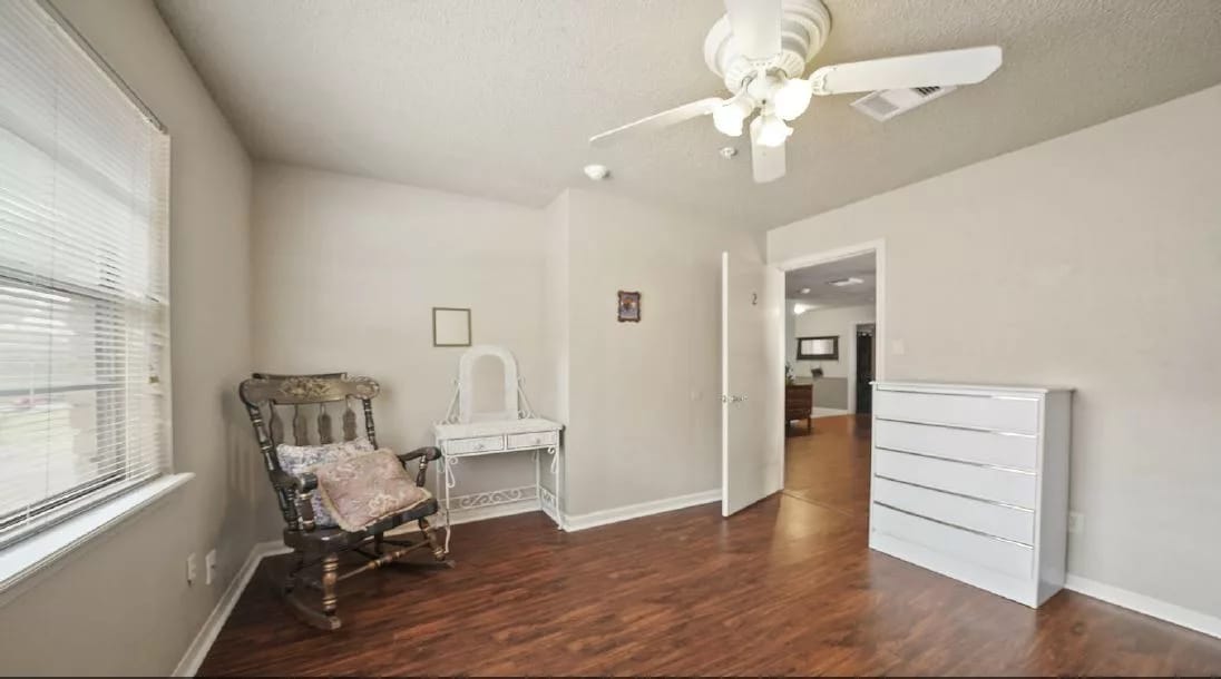 Interior view of a cozy room with a rocking chair and dresser.