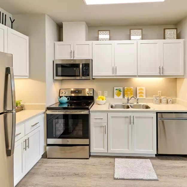 Bright kitchen with white cabinets and stainless steel appliances