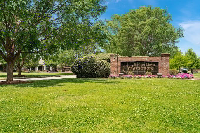 Entrance sign of Heritage Manor Stratmore Nursing & Rehabilitation Center surrounded by greenery