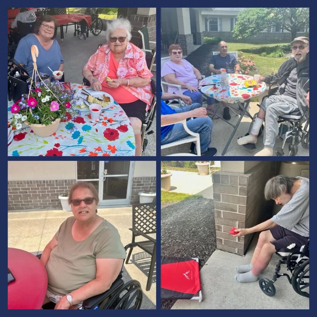 Residents sitting and interacting around tables outdoors.