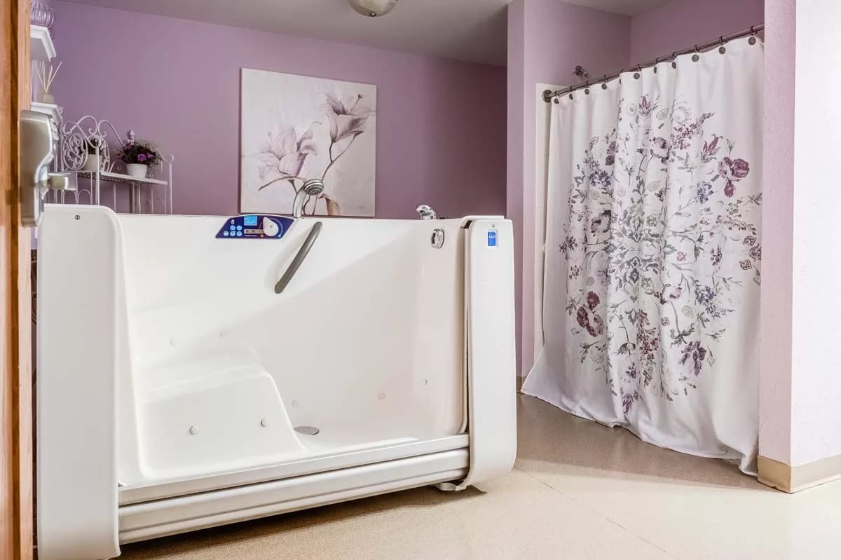 Accessible bathtub in a bathroom with floral shower curtain