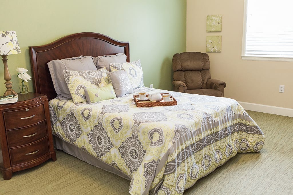 Comfortable bedroom with patterned bedding and a recliner chair