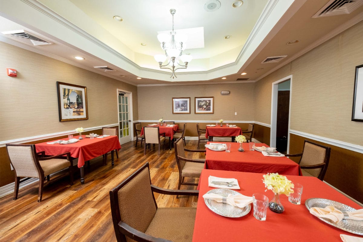 Dining room with red tablecloths and floral centerpieces