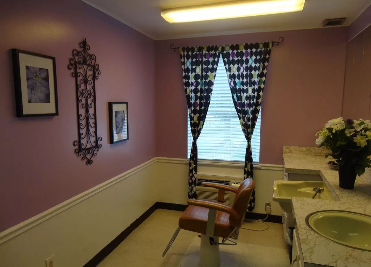 Interior view of a hair salon with a chair and decorative curtains
