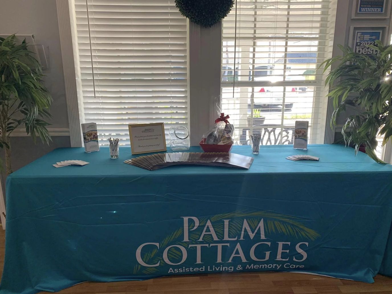 Reception table with brochures and a decorative basket at Palm Cottages.