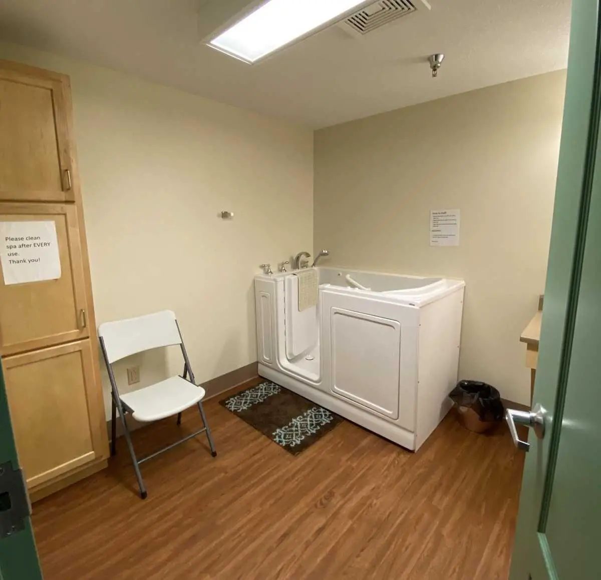 Bathroom with an accessible spa tub and a folding chair