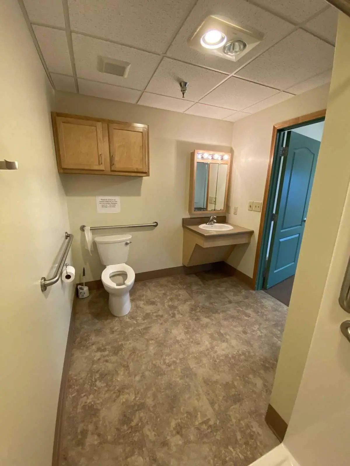 Accessible bathroom with sink, toilet, and storage cabinets