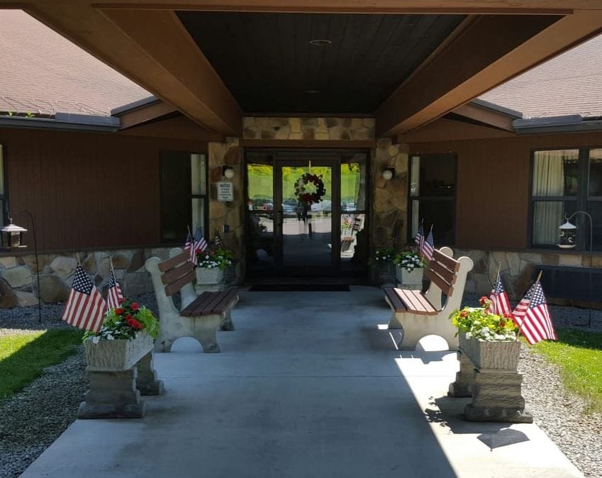 Welcoming entrance with benches and flower pots at Siemon's Heritage Personal Care Home