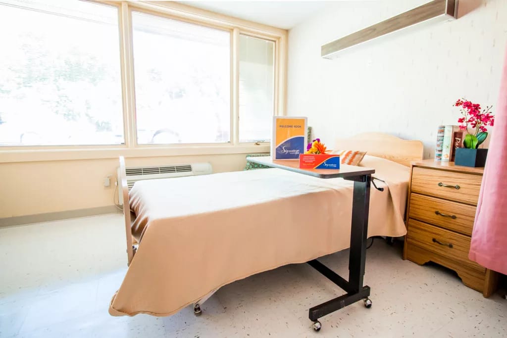 Cozy bedroom setup with a bed, bedside table, and window natural light