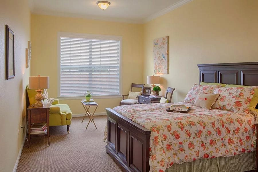 A bright and inviting bedroom with floral bedding and a large window.